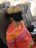 Woman in airplane seat wearing face mask 