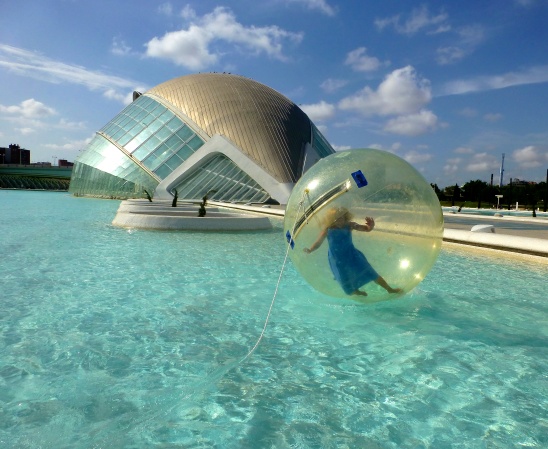 Blonde woman floating in a bubble at the City of Arts and Sciences Valencia Spain